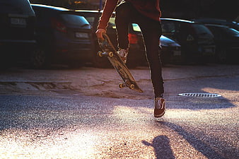 Skateboarder Walking with Board in Parking Lot