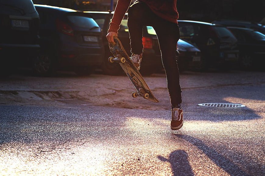 Skateboarder Walking with Board in Parking Lot