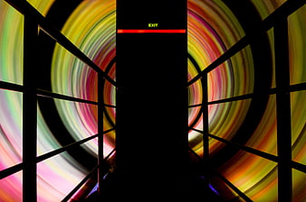 Colorful spinning fairground attraction with exit sign