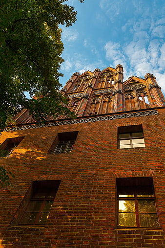 Low angle view of historic red brick architecture against blue sky