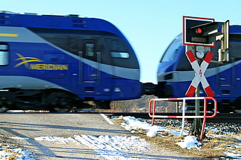 Blue Werdan Train Passing Railroad Crossing in Winter