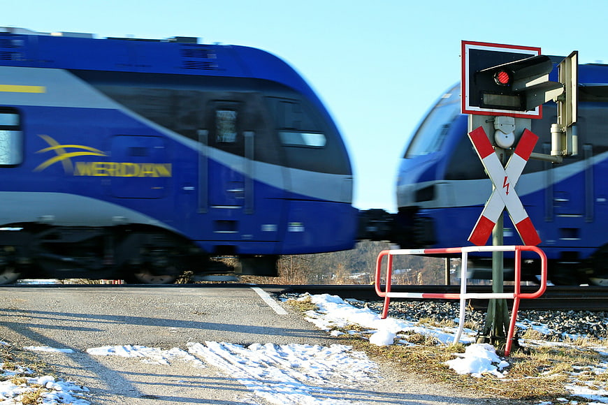 Blue Werdan Train Passing Railroad Crossing in Winter