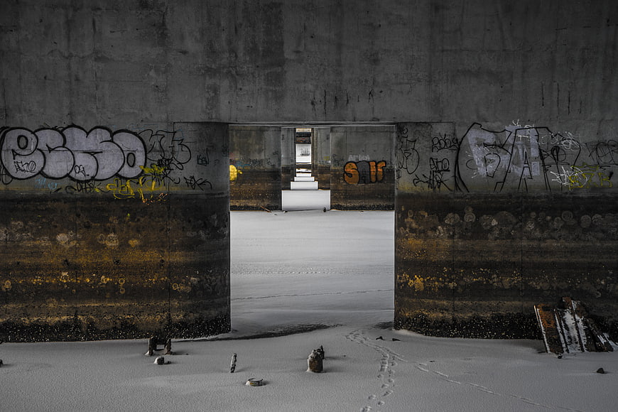 Snowy Concrete Tunnel with Graffiti and Footprints