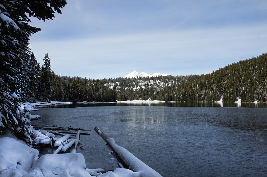 Serene Winter Lake Landscape with Snowy Mountains and Forest
