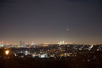 London City Skyline at Night with Airplane Trail