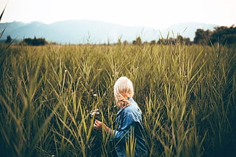 Blonde Woman in Wheat Field with Mountains