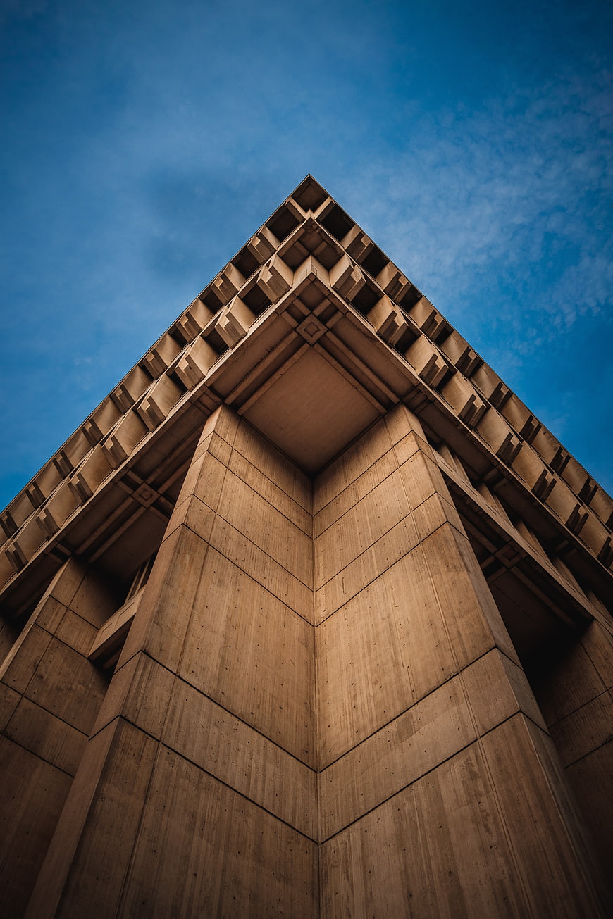 Low angle view of modern concrete building corner against blue sky