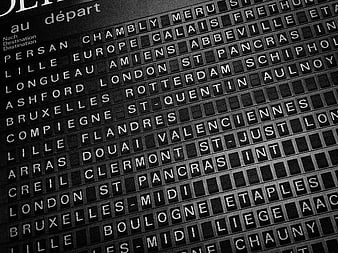 Black and white train station departure board with city names