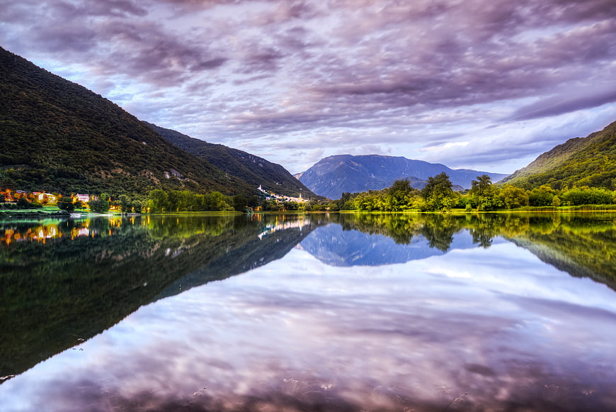 Serene Lake Reflection with Mountains and Dramatic Clouds