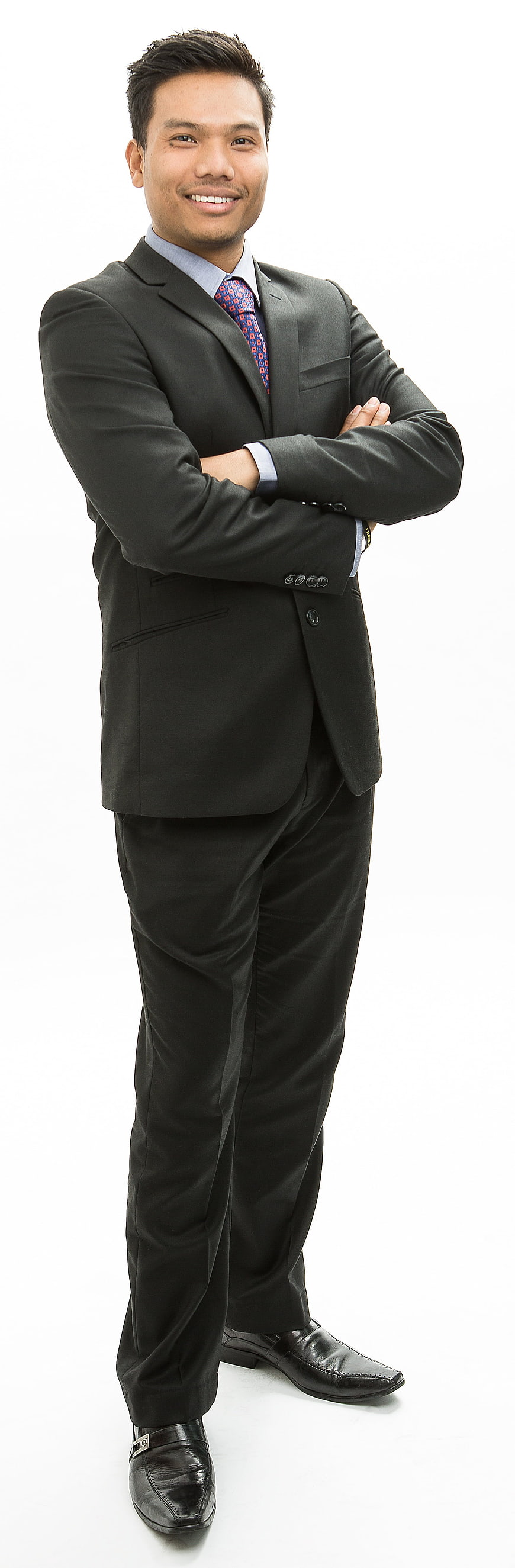 Asian businessman in black suit standing with arms crossed