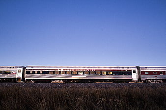 American Spirit Train on Tracks Against Blue Sky