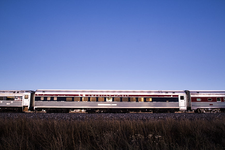 American Spirit Train on Tracks Against Blue Sky