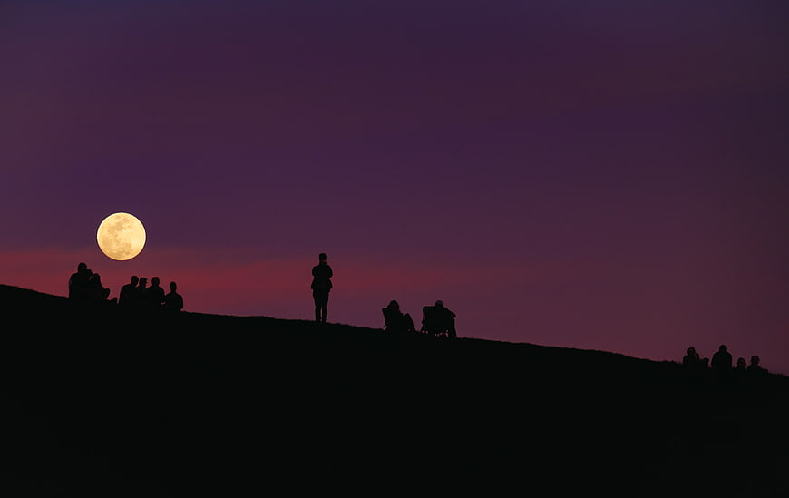 Silhouettes of People Watching Full Moon on Hill at Dusk