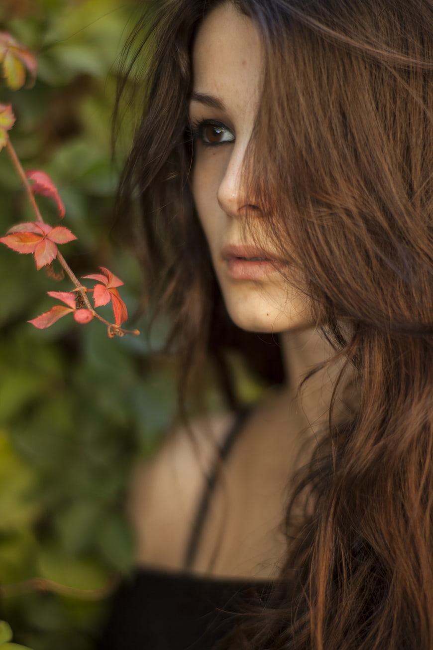 Portrait of Woman with Windblown Hair and Red Leaves