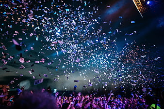 Crowd at concert throwing money confetti in the air