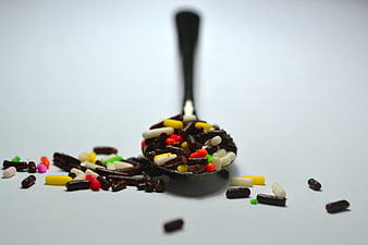 Colorful Pills In A Spoon On White Background