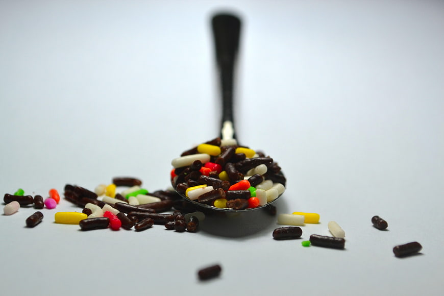 Colorful Pills In A Spoon On White Background