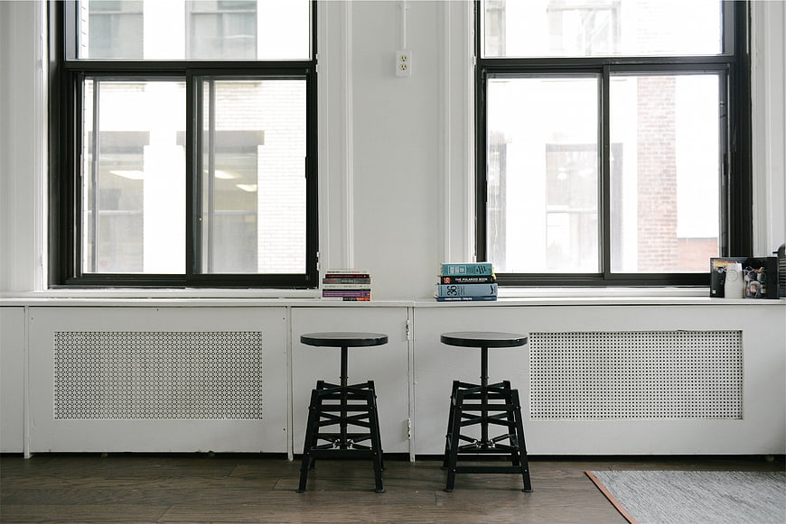 Minimalist interior with black stools and large windows