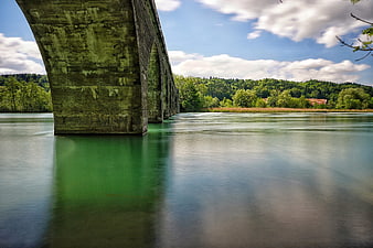Long exposure of stone bridge over green river in Switzerland