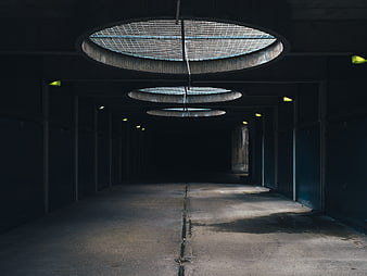 Dark underground parking garage with circular skylights