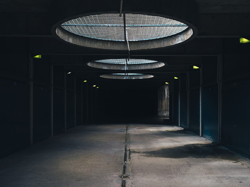Dark underground parking garage with circular skylights