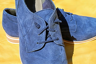 Blue suede casual shoes on yellow background