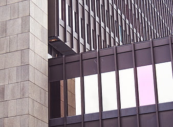 Modern building facade with geometric patterns and pink window reflection