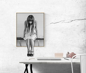 Sad woman sitting on bench in black and white framed art