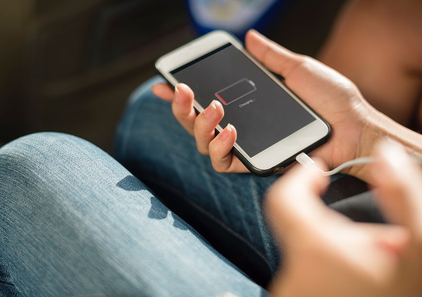 Woman Plugging In Smartphone With Low Battery Icon