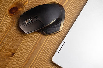 Black Wireless Mouse and Silver Laptop on Wooden Desk