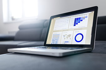 Laptop displaying analytics dashboard on sofa