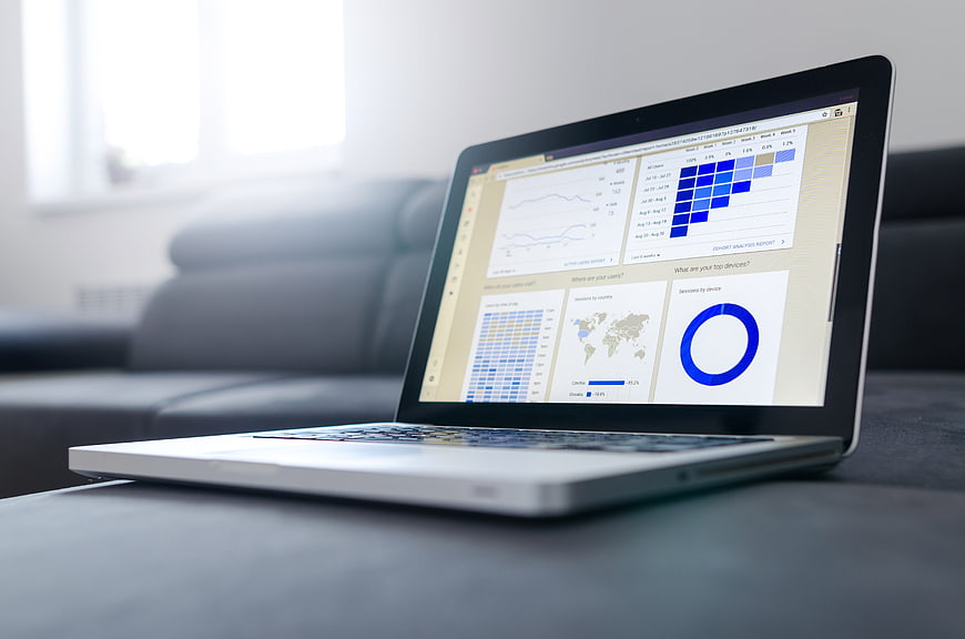 Laptop displaying analytics dashboard on sofa