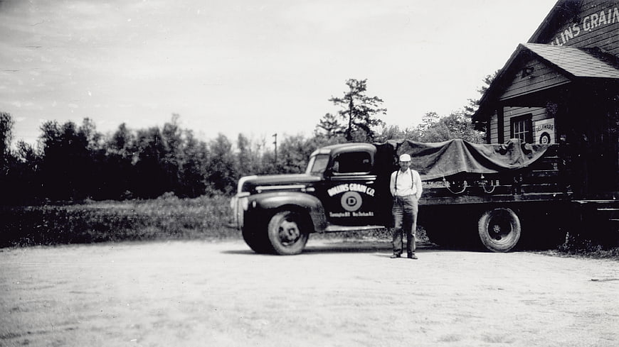 Vintage black and white photo of man with old truck