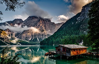 Serene Alpine Lake with Wooden Boathouse and Mountain Reflections