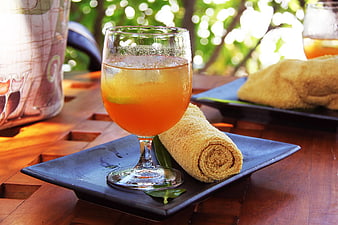 Refreshing Orange Cocktail with Rolled Towel on Wooden Table