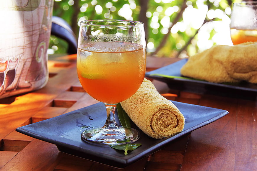Refreshing Orange Cocktail with Rolled Towel on Wooden Table