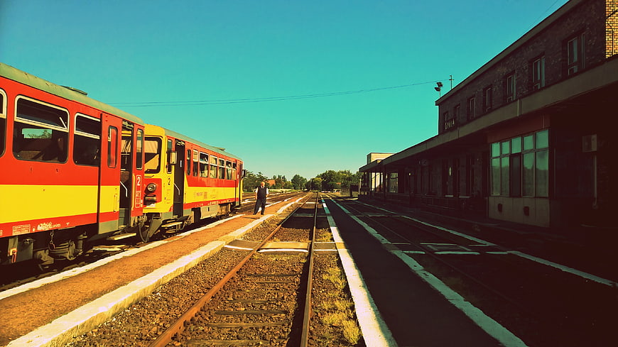 Red and yellow train at sunny railway station platform