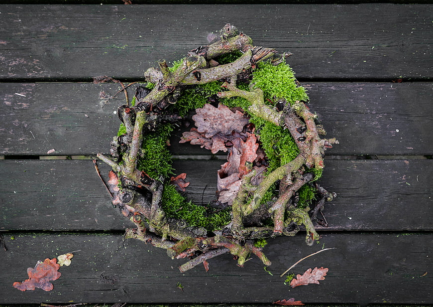 Rustic moss and twig wreath on dark wooden planks