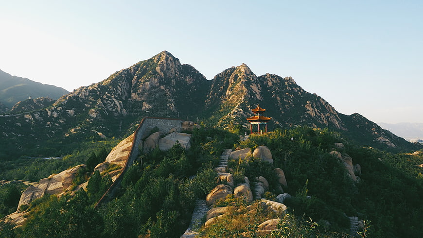 Traditional Chinese Pavilion on Rocky Mountain Peak at Sunset