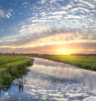 Serene River Landscape with Golden Sunset and Cloud Reflections
