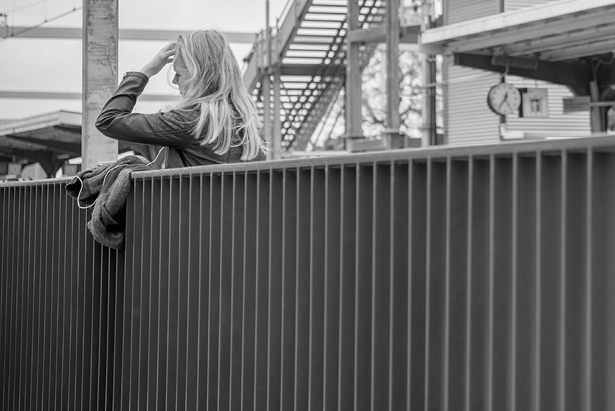 Woman in leather jacket waiting at train station platform