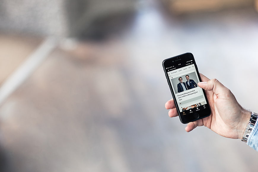 Hand Holding Smartphone Displaying Business News Article