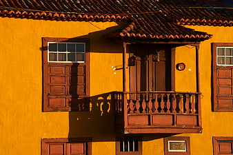 Yellow Spanish House with Wooden Balcony and Shutters