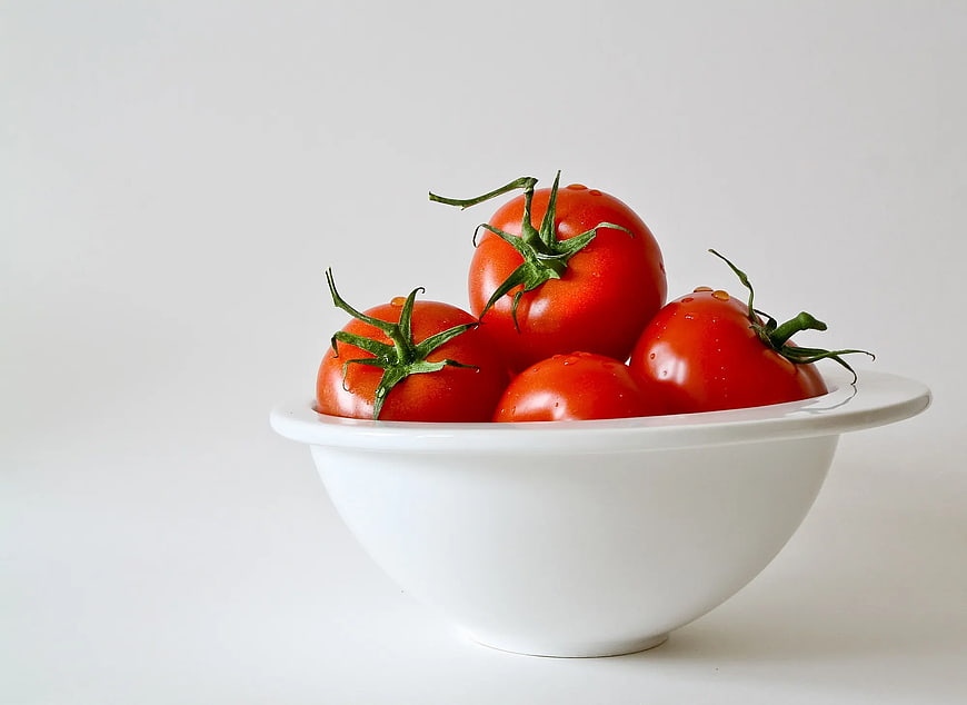 Fresh Red Tomatoes in White Bowl on White Background