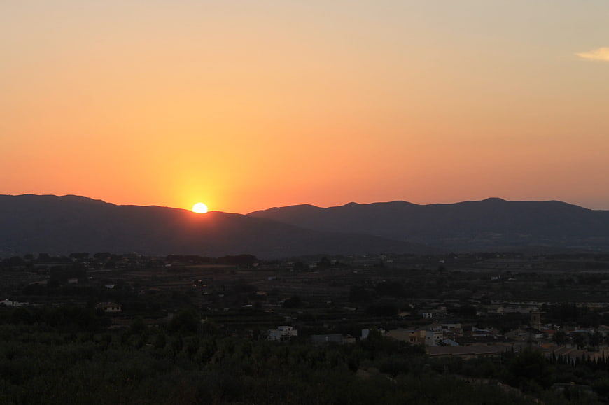 Sunset over mountain range and rural valley landscape
