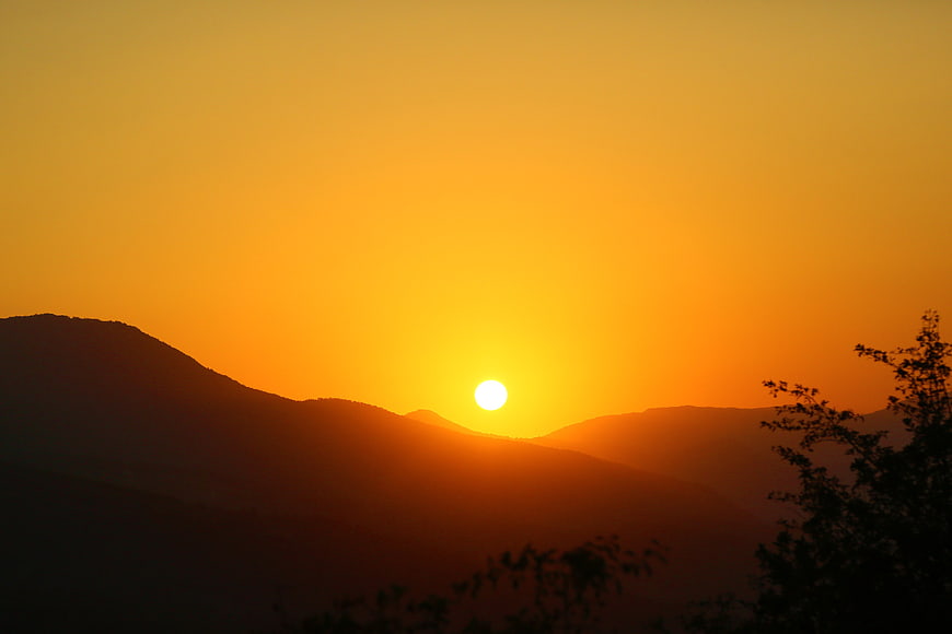 Golden Sunset Over Silhouetted Mountain Ranges
