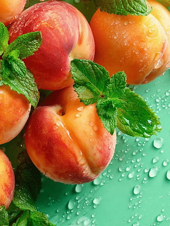 Fresh Juicy Peaches with Mint Leaves on Green Background