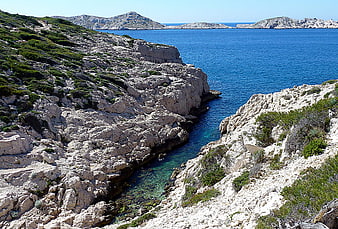 Rugged Mediterranean coastline with turquoise cove and rocky cliffs