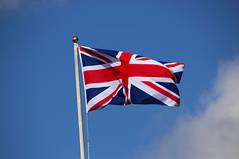 Union Jack Flag Waving Against Blue Sky