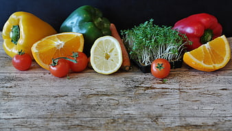 Fresh vegetables and citrus fruits on rustic wooden table